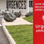 le long d'une route, un panneau de signalisation indique la direction à prendre pour accéder aux urgences pédiatriques