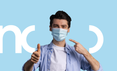 un homme portant un masque chirurgical lève le pouce en signe de satisfaction