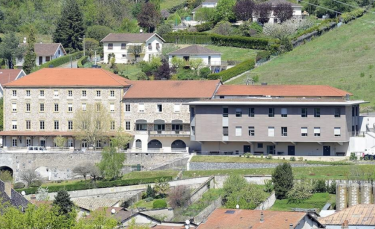 vue aérienne de la façade d'un grand bâtiment de trois niveaux construit sur un terrain en pente