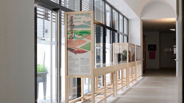 une exposition dans de grandes vitrines structure bois est installée dans un couloir lumineux de l'hôpital de Beaujeu