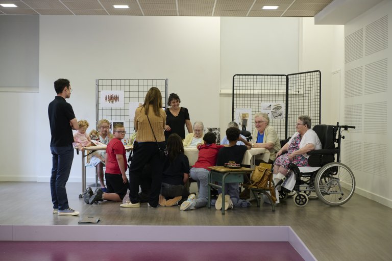 dans une salle d'exposition des personnes âgées discutent avec des adolescents