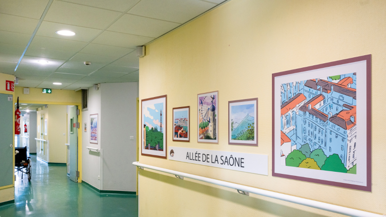 de grands dessins encadrés sont fixés sur un mur jaune. sous les dessins il est écrit allée de la saône