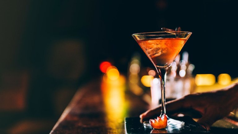 un verre à cocktail est posé sur un bar 