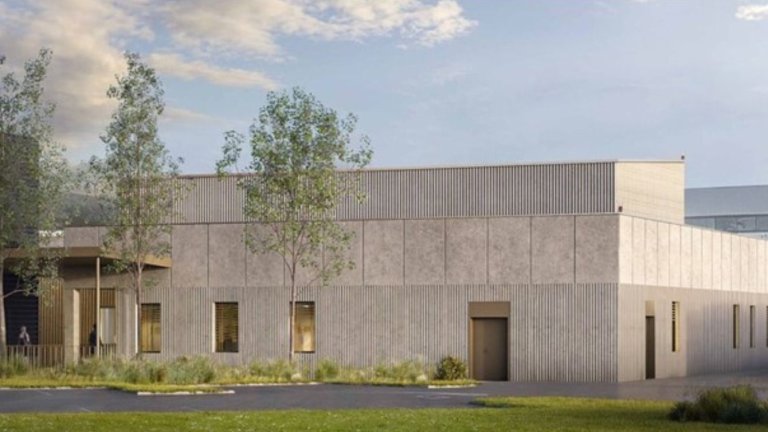 un grand bâtiment aux façades claires se déploit en rez-de-chaussée